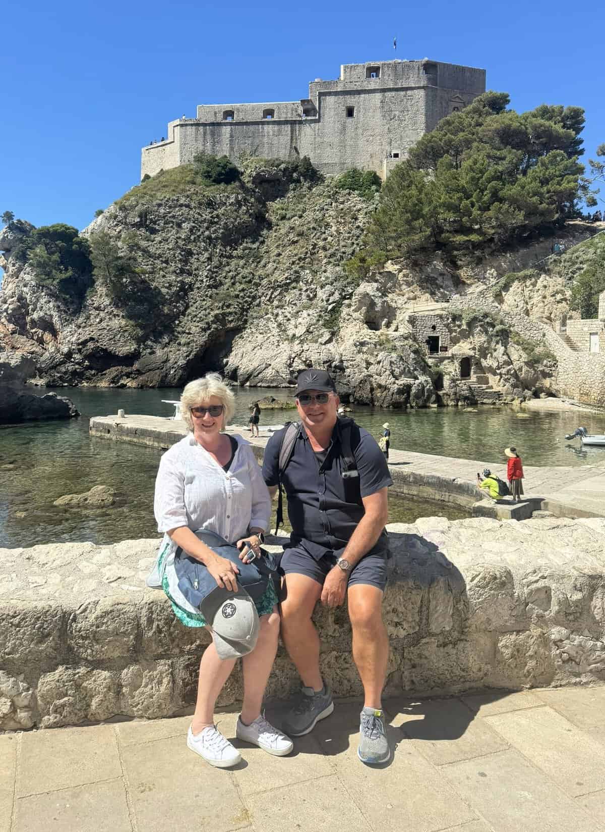 Alison & Wayne seated in front of Fort Lovrijenac in Dubrovnik.
